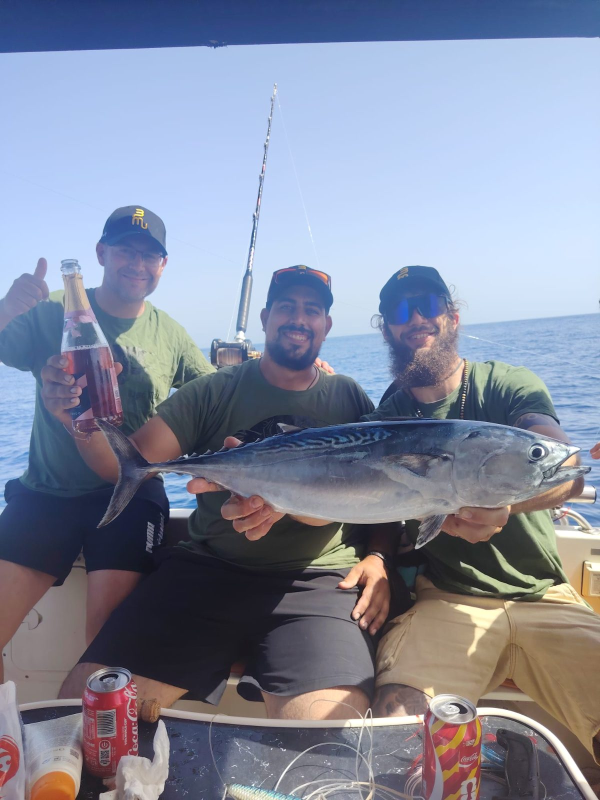 Tres amigos con un bonito recién pescado en Málaga